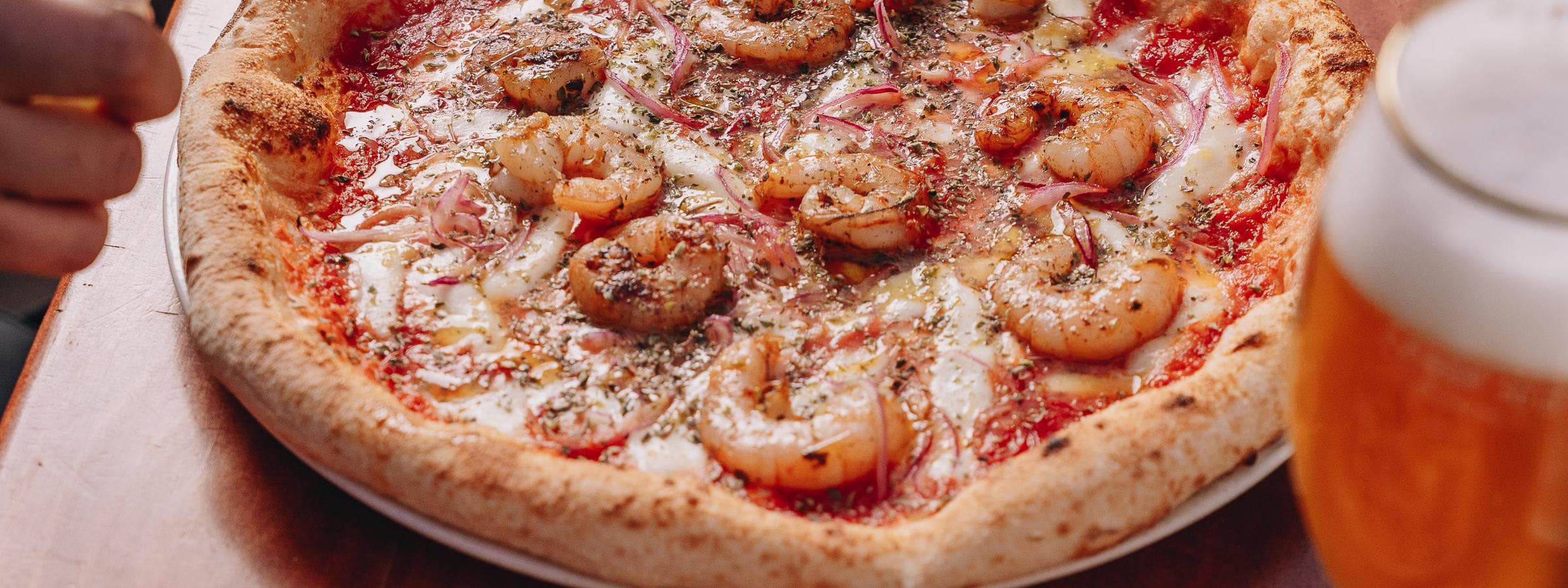 Pizza con camarones y una cerveza